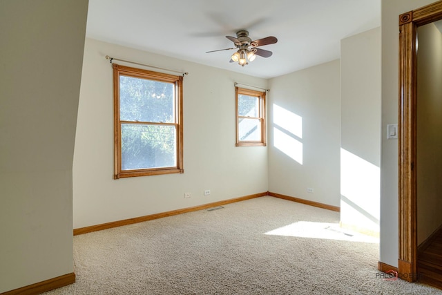 carpeted spare room featuring ceiling fan