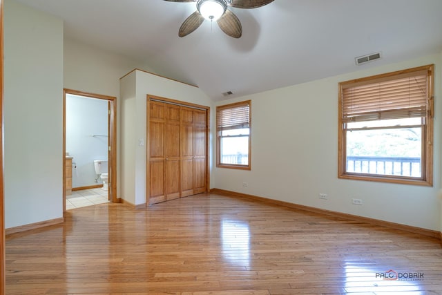 unfurnished bedroom with ceiling fan, light hardwood / wood-style floors, a closet, and multiple windows