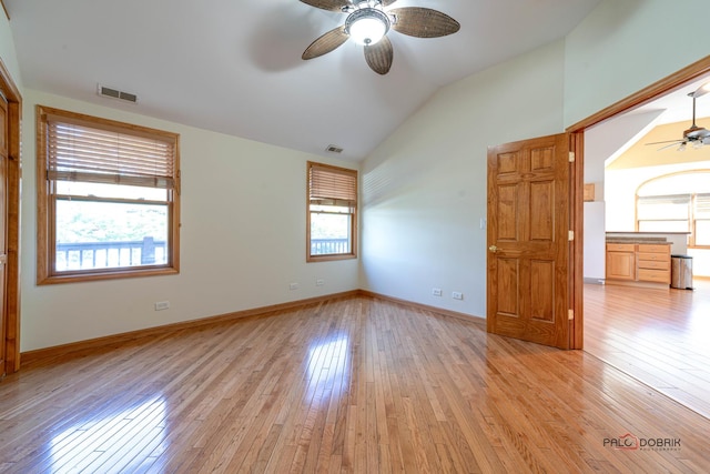 unfurnished bedroom with white fridge, light hardwood / wood-style flooring, ceiling fan, and lofted ceiling