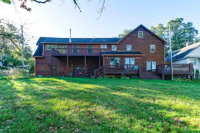 back of house featuring a lawn and a wooden deck