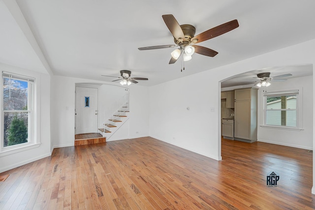 unfurnished living room with light wood-type flooring and ceiling fan