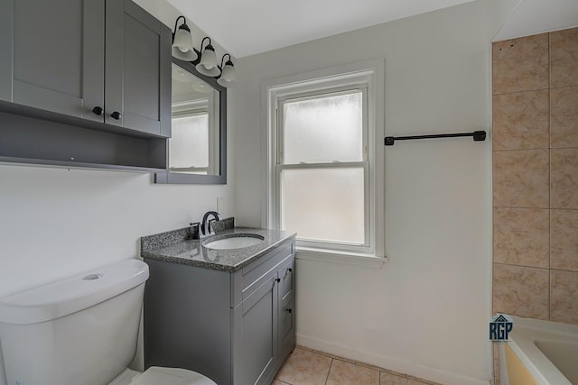 bathroom featuring toilet, vanity, tile patterned floors, and a bathing tub