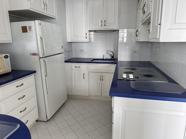 kitchen featuring white cabinets, white refrigerator, sink, and tasteful backsplash