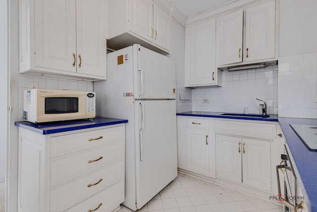 kitchen featuring sink, backsplash, white appliances, and white cabinets