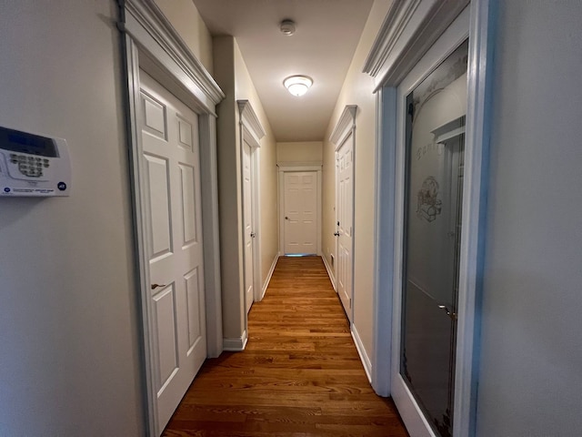 corridor with hardwood / wood-style flooring