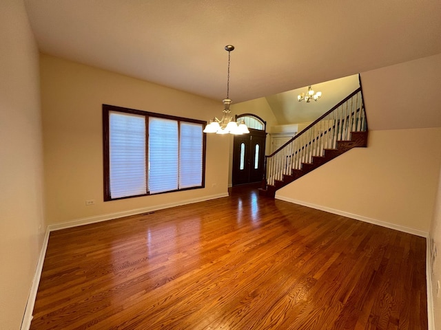 interior space with hardwood / wood-style flooring, lofted ceiling, and an inviting chandelier