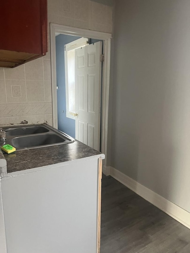 kitchen featuring decorative backsplash, sink, and dark wood-type flooring