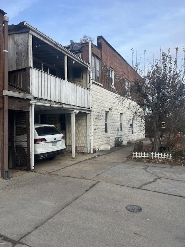 view of property exterior with a carport and a balcony