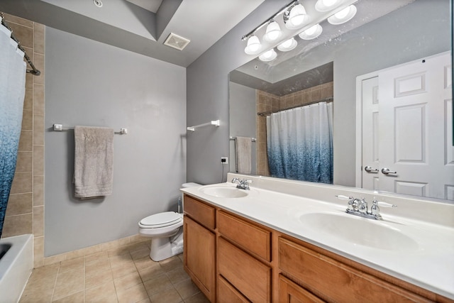 bathroom with toilet, vanity, and tile patterned floors