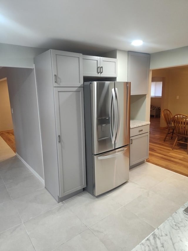 kitchen with gray cabinetry, stainless steel fridge with ice dispenser, and light hardwood / wood-style flooring