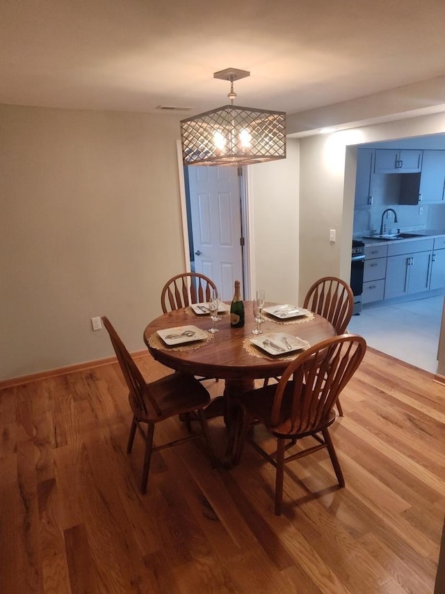 dining room with sink and light hardwood / wood-style flooring