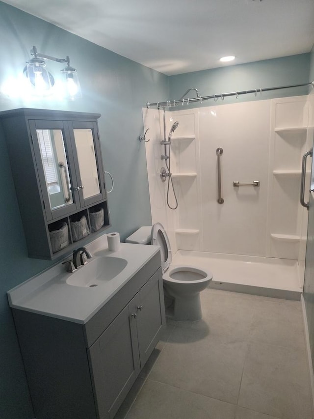 bathroom with toilet, vanity, tile patterned floors, and walk in shower