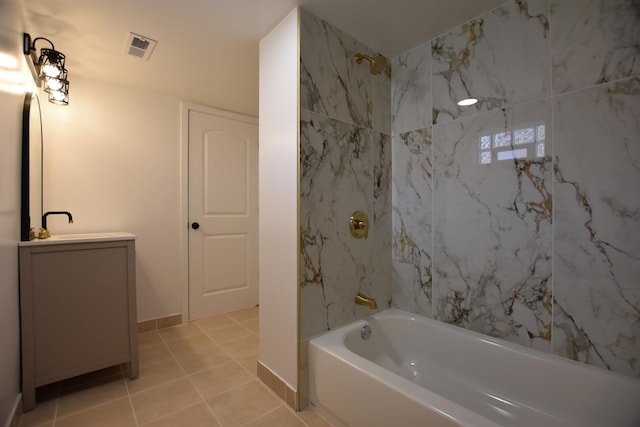 bathroom with tile patterned flooring, tiled shower / bath combo, and sink