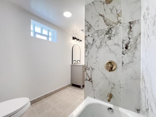 bathroom featuring tile patterned floors, toilet, and tiled shower / bath