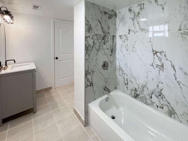 bathroom with tile patterned flooring, vanity, and tiled shower / bath combo