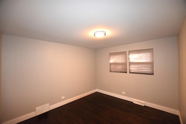 empty room with dark hardwood / wood-style flooring