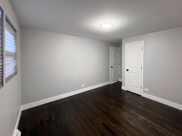 spare room featuring dark wood-type flooring