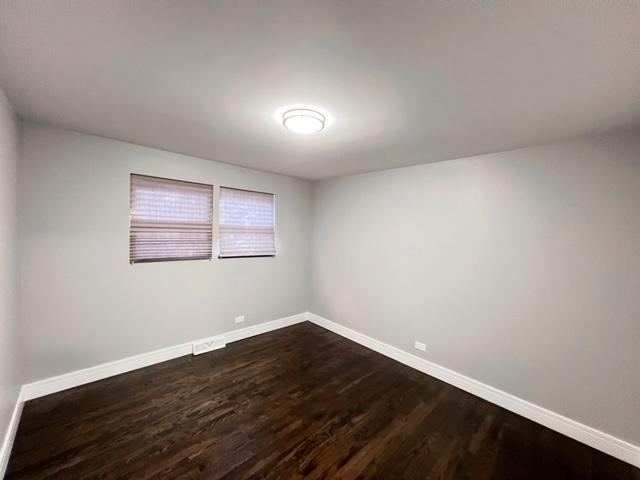 spare room featuring dark wood-type flooring