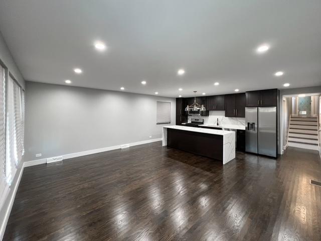 kitchen featuring hanging light fixtures, a kitchen island, dark hardwood / wood-style floors, and stainless steel refrigerator with ice dispenser