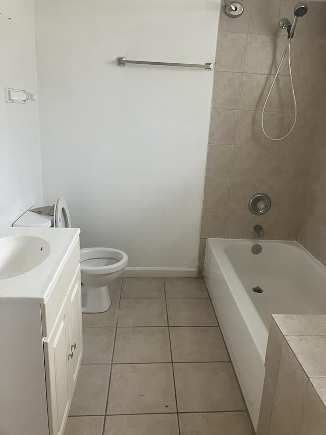 full bathroom featuring tile patterned flooring, vanity, toilet, and tiled shower / bath combo