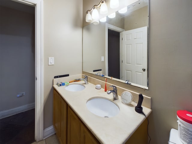 bathroom with tile patterned flooring, vanity, and toilet