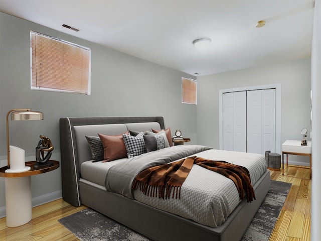 bedroom with a closet, multiple windows, and light hardwood / wood-style flooring