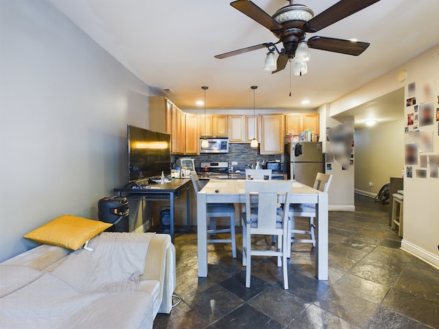 kitchen with appliances with stainless steel finishes, light brown cabinetry, tasteful backsplash, ceiling fan, and hanging light fixtures