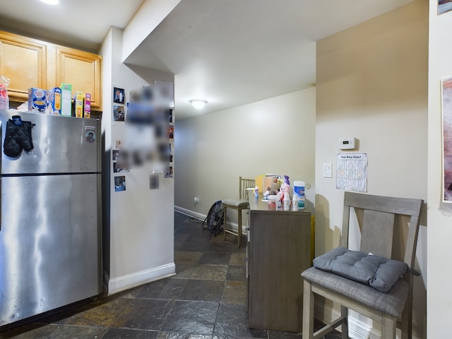 kitchen featuring stainless steel fridge and light brown cabinetry