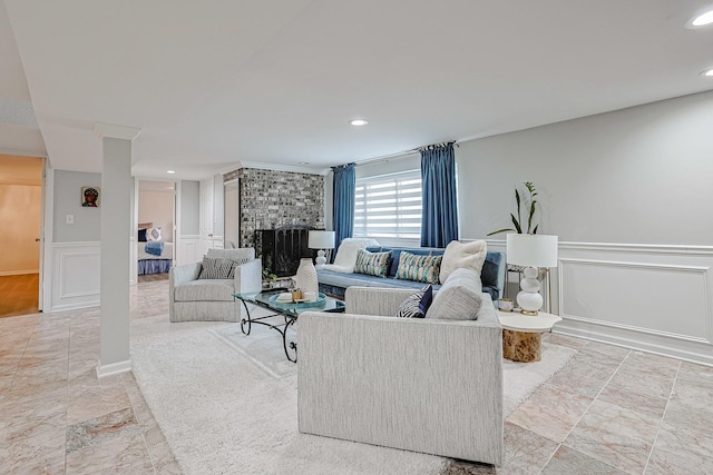 living area with recessed lighting, a wainscoted wall, a fireplace, and a decorative wall