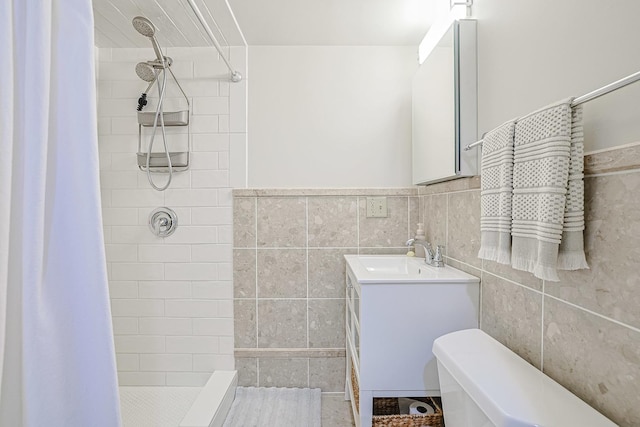 full bath with vanity, a shower stall, toilet, and tile walls