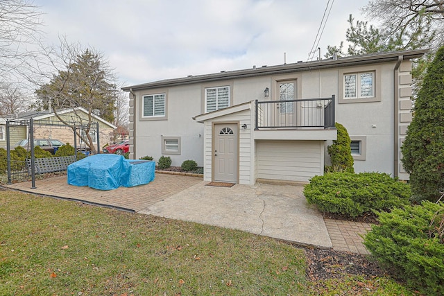 back of property featuring a lawn, a pergola, a balcony, and stucco siding