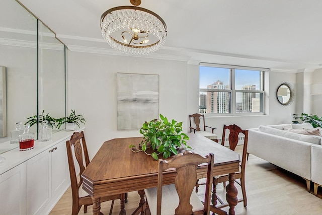 dining area featuring ornamental molding, light wood-type flooring, and a notable chandelier