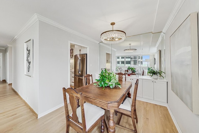 dining room featuring an inviting chandelier, ornamental molding, and light hardwood / wood-style floors