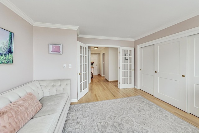 living room with french doors, light wood-type flooring, and crown molding