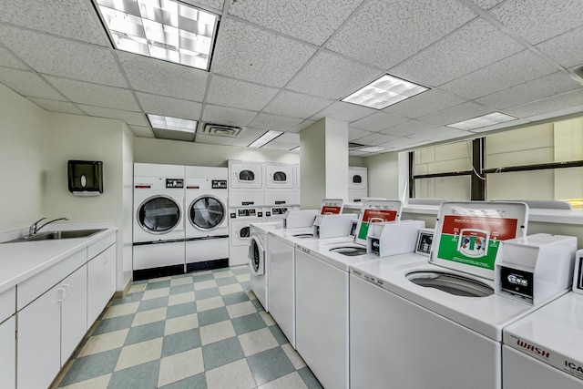 clothes washing area with sink, washing machine and clothes dryer, and stacked washer and dryer