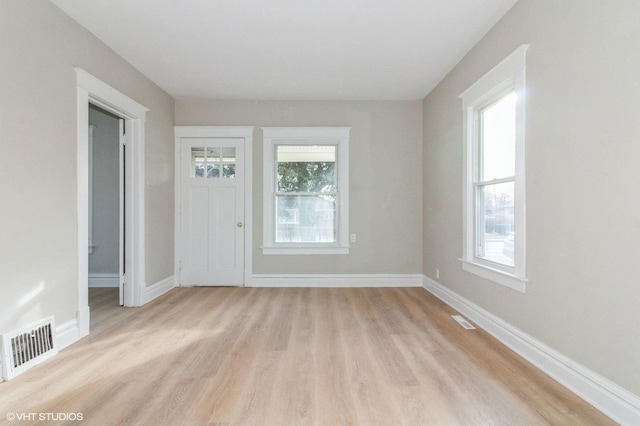 unfurnished room featuring light hardwood / wood-style flooring and a healthy amount of sunlight