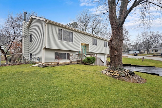 back of house featuring a wooden deck and a yard