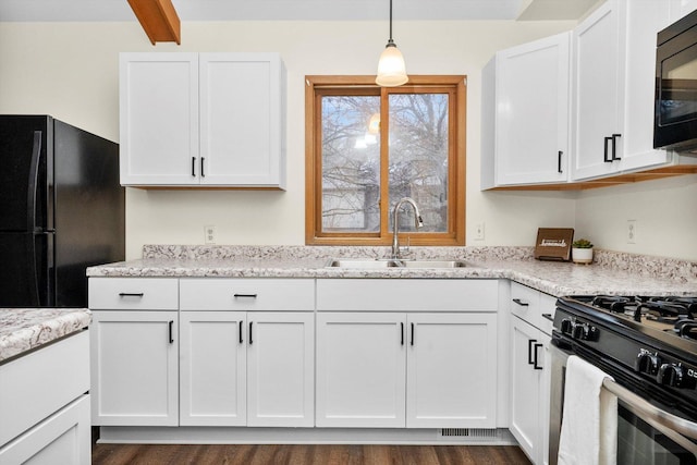 kitchen featuring sink, dark hardwood / wood-style floors, decorative light fixtures, white cabinets, and black appliances