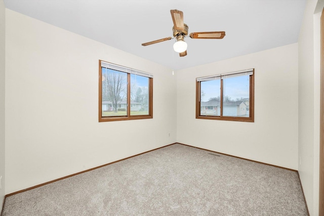 unfurnished room with light colored carpet and ceiling fan