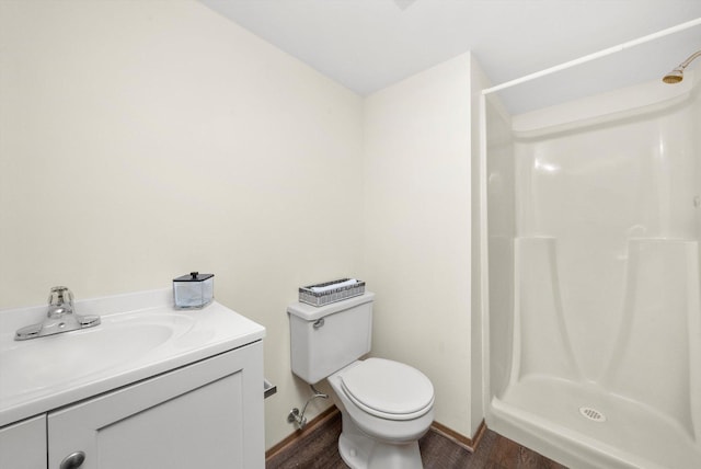 bathroom with a shower, vanity, hardwood / wood-style flooring, and toilet