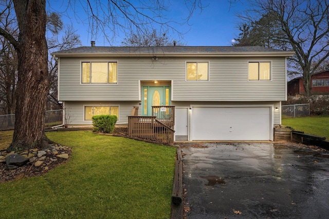 raised ranch with a front lawn and a garage