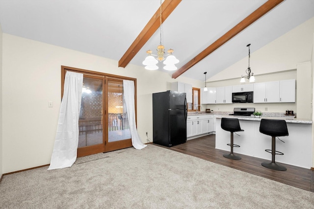 kitchen with pendant lighting, white cabinets, black appliances, and dark colored carpet