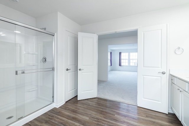 bathroom featuring an enclosed shower, vanity, and hardwood / wood-style floors