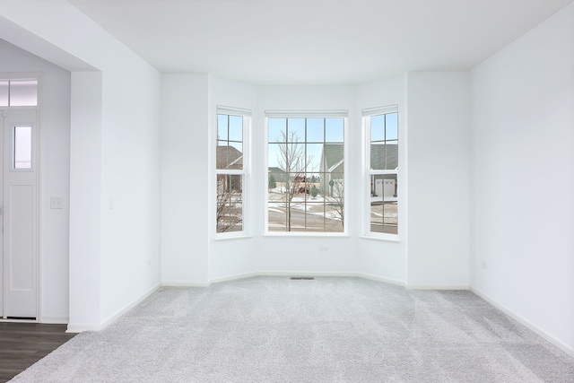 unfurnished room with dark carpet