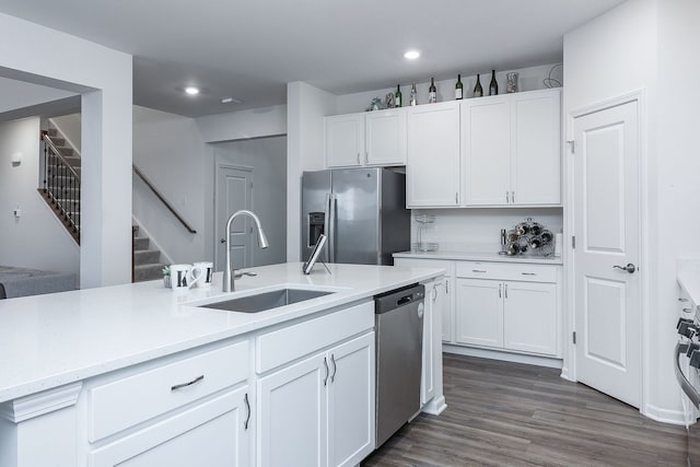 kitchen with sink, stainless steel appliances, dark hardwood / wood-style floors, light stone counters, and white cabinets