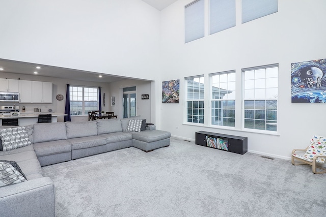 carpeted living room with a high ceiling