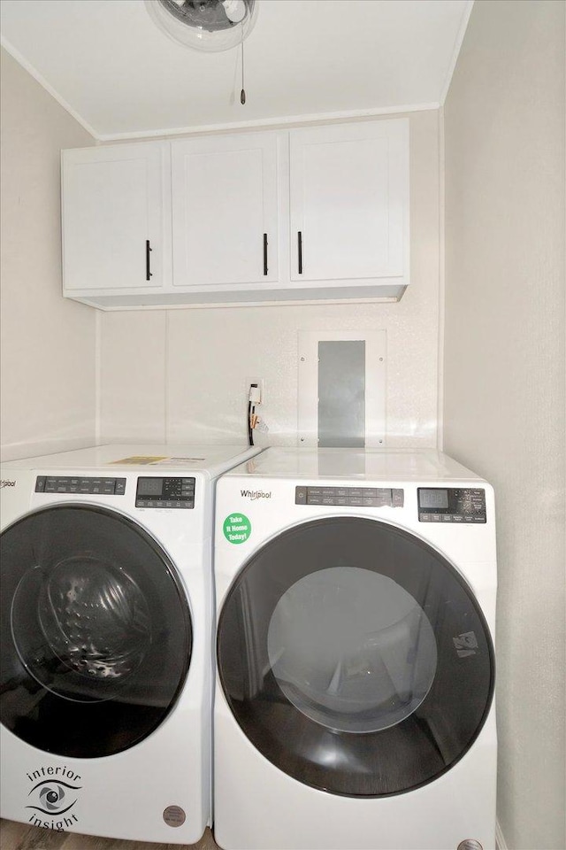 laundry room featuring cabinets, ornamental molding, and washing machine and clothes dryer