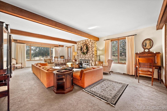 carpeted living room featuring beam ceiling and a stone fireplace