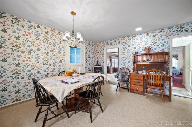 carpeted dining area featuring a chandelier