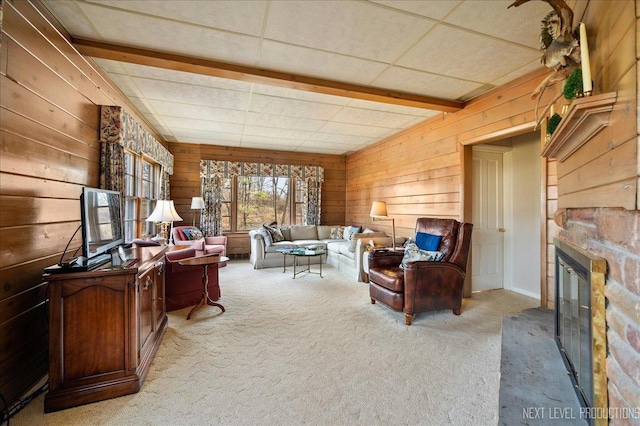 carpeted living room featuring beam ceiling and wood walls